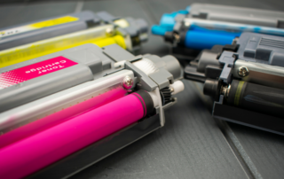 An image displaying an assortment of colorful printer toner cartridges set against a white background. The vibrant cyan, magenta, yellow, and black toners are arranged in a neat row, highlighting the variety and quality of the toner products available.