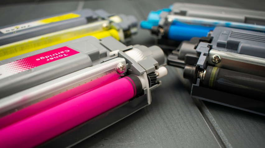 An image displaying an assortment of colorful printer toner cartridges set against a white background. The vibrant cyan, magenta, yellow, and black toners are arranged in a neat row, highlighting the variety and quality of the toner products available.